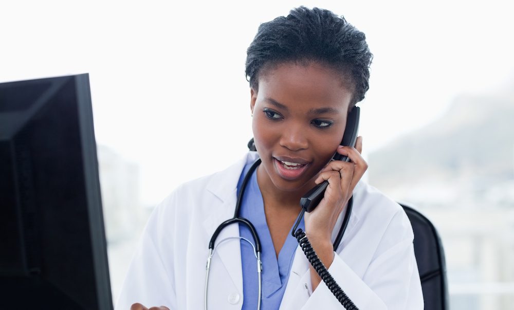 Female doctor on the phone while using a computer